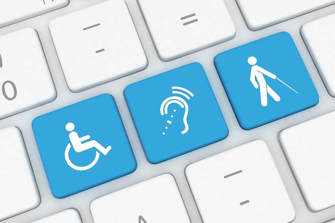 Tastatur mit blauen Tasten, die Symbole für Barrierefreiheit darstellen: Rollstuhl, Hörgerät und Blindenstock