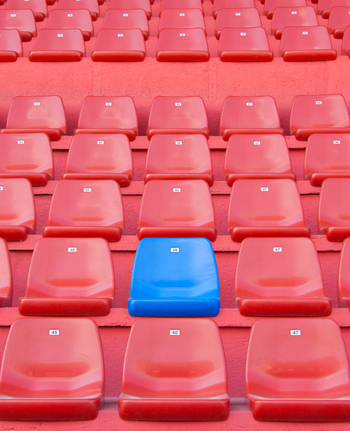 Bild einer roten Tribüne mit einem einzelnen blauen Stuhl